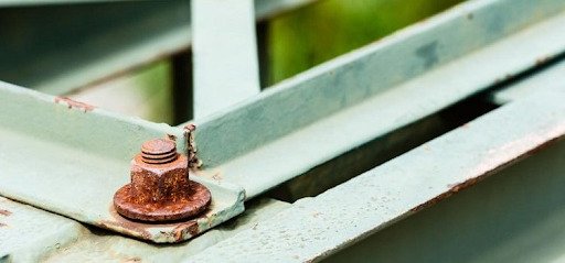 Figura 4 - Parafuso e porca sofrendo corrosão galvânica em estrutura metálica. A corrosão em parafusos é preocupante, pois pode causar falhas graves na estrutura Figura 4 - Parafuso e porca sofrendo corrosão galvânica em estrutura metálica. A corrosão em parafusos é preocupante, pois pode causar falhas graves na estrutura