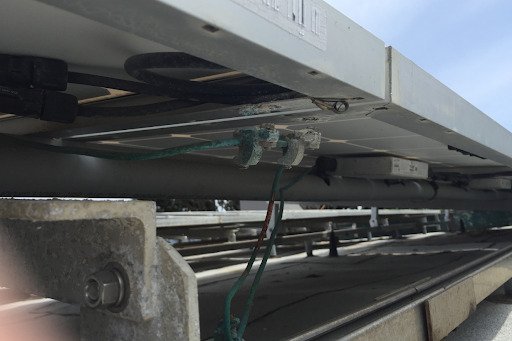 Figura 7 - O mecanismo de fixação entre o fio de cobre e o módulo continha metais incompatíveis. O processo de degradação foi acelerado pela maresia Figura 7 - O mecanismo de fixação entre o fio de cobre e o módulo continha metais incompatíveis. O processo de degradação foi acelerado pela maresia