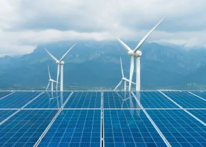 Conjunto de painéis solares e turbinas eólicas em um campo montanhoso, destacando as principais fontes de energia renováveis do mundo.