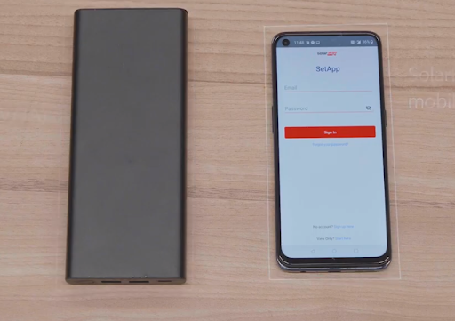 Componentes necessários para o pré-comissionamento do sistema Synergy: (1) banco de baterias USB (60 W / 20 V / 3 A) com conector do tipo USB-C e (2) telefone celular com o aplicativo SolarEdge SetApp