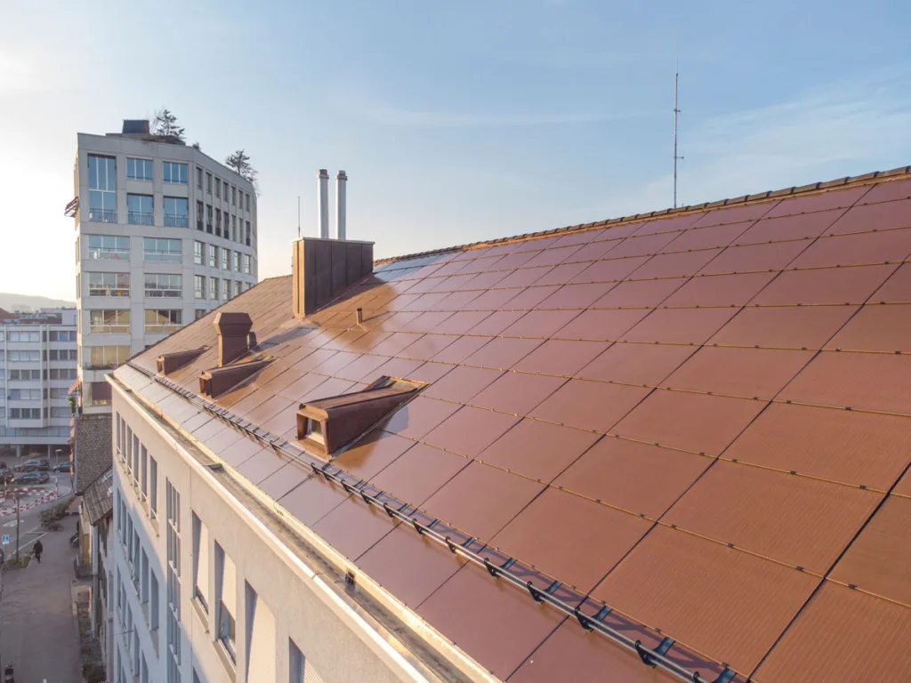 Cobertura com módulos fotovoltaicos terracota, mesma cor do telhado original. (Solaxess)