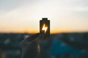 Mulher segurando símbolo de energia entre a luz do sol