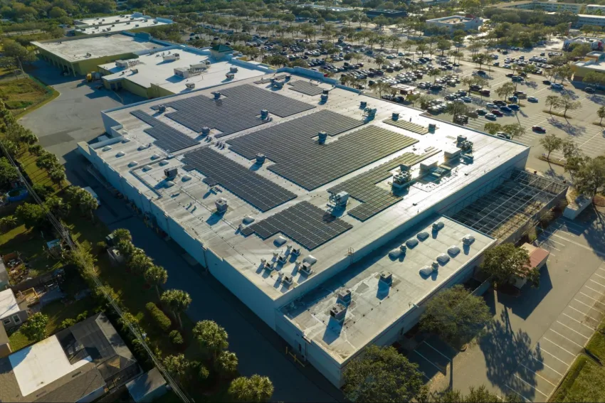 Pavilhão grande de empresa com diversos painéis de energia solar no telhado